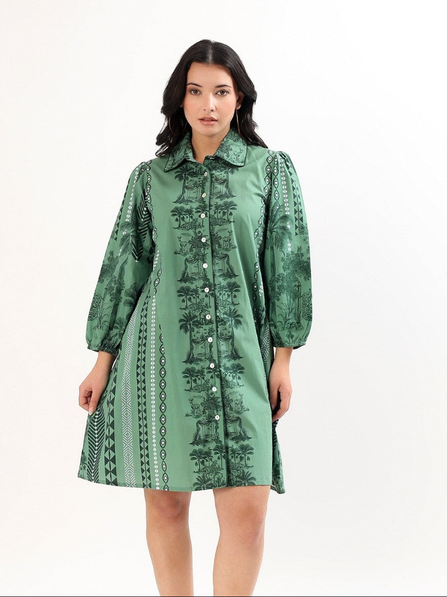 Woman wearing a green hand printed patterned dress on a white background
